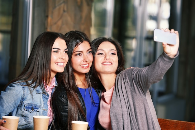 Attraktive Mädchen zusammen nehmen Selfie, das im Café sitzt