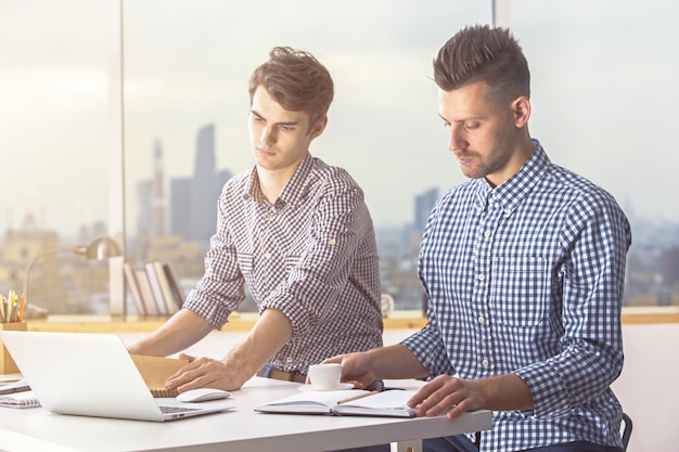 Attraktive Männer, die an einem Projekt arbeiten