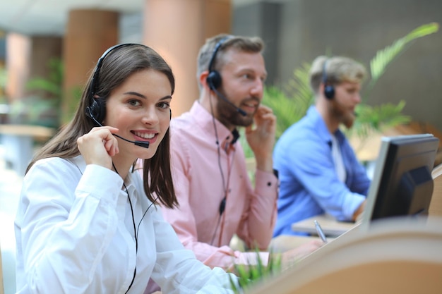 Attraktive positive junge Geschäftsleute und Kollegen in einem Call-Center-Büro.