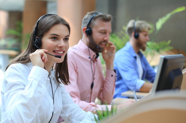 Attraktive positive junge Geschäftsleute und Kollegen in einem Call-Center-Büro.