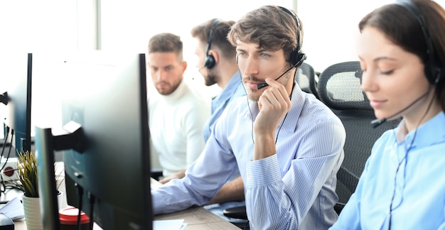 Attraktive positive junge Geschäftsleute und Kollegen in einem Callcenter-Büro.