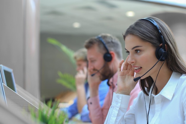 Attraktive positive junge Geschäftsleute und Kollegen in einem Callcenter-Büro.