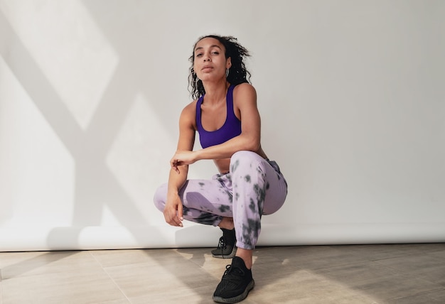 Attraktive schwarze afroamerikanerin im stylischen hipster-fitness-outfit im hintergrund