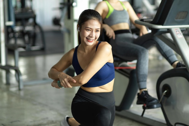 Attraktive sportliche Frau, die ihren Trainingsprozess im Fitnessstudio genießt. Frau macht Übung, Cardio-Training.