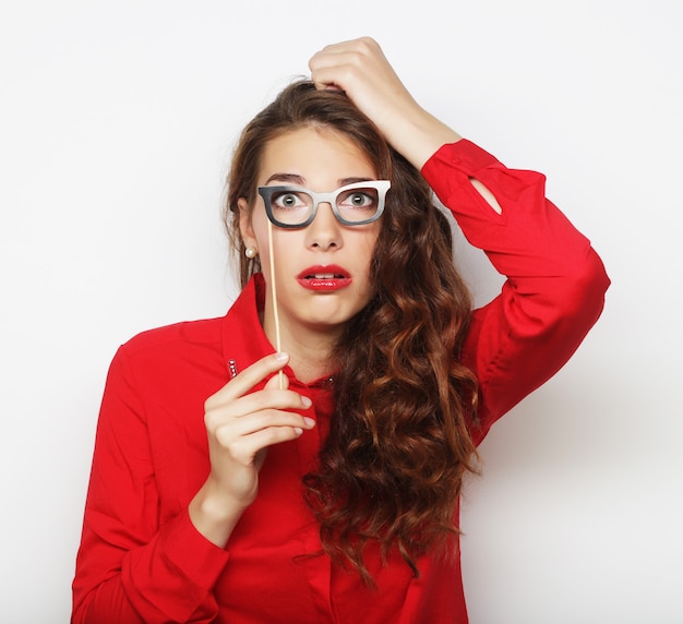 Attraktive verspielte junge Frau mit falscher Brille, bereit für die Party