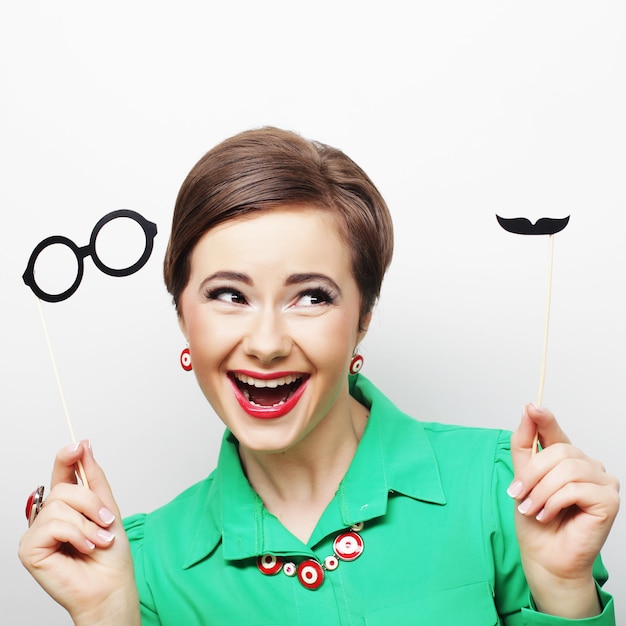 Foto attraktive verspielte junge frau mit schnurrbart und brille auf einem stock. bereit für die party.