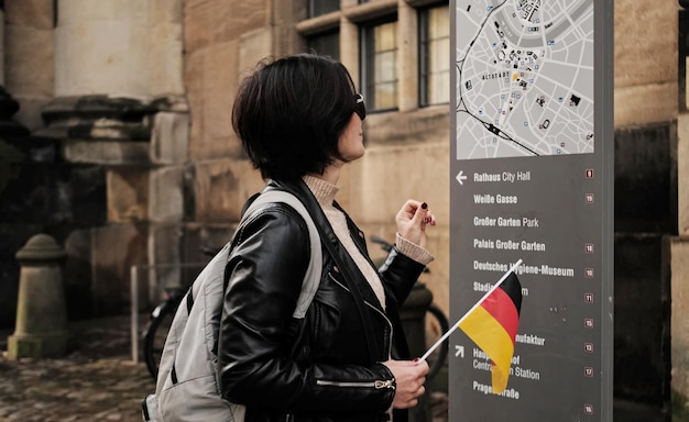 Foto attraktive weibliche touristen spazieren mit deutscher flagge im historischen zentrum von dresden