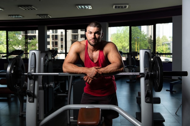 Attraktiver junger Mann, der sich nach dem Training im Fitnessstudio ausruht