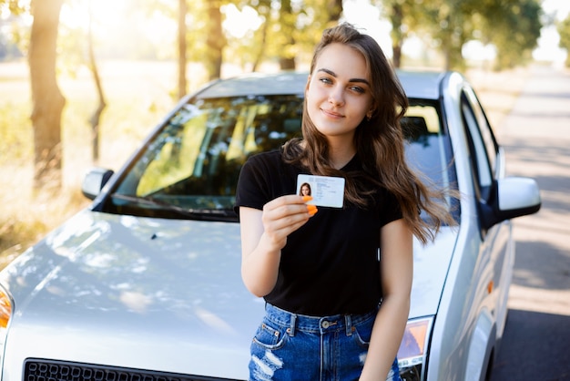 Attraktiver kaukasischer Fahrer, der ihren Führerschein zeigt