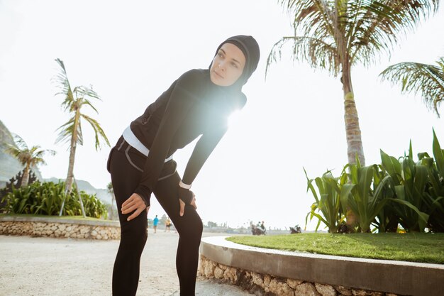 Attraktiver Läufer, der nach dem Joggen im Freien eine Pause macht