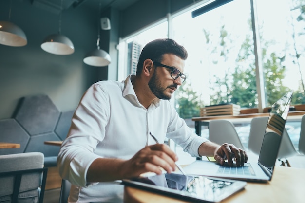 Attraktiver Mann, der im Café arbeitet