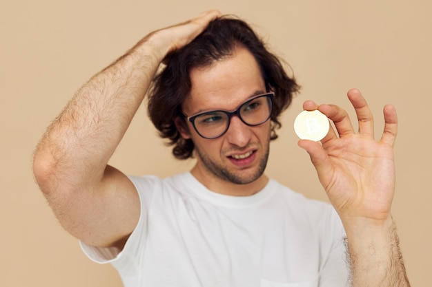 Attraktiver Mann in einem weißen T-Shirt mit unverändertem Bitcoin-Kryptowährungslebensstil