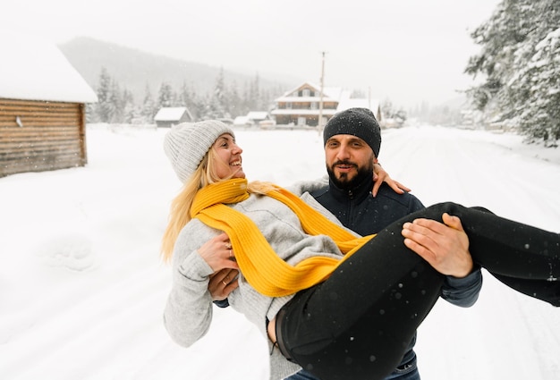 Attraktiver Mann und Frau, die im frostigen Wald kuscheln. Erwachsene Paare in Pullovern haben Spaß beim Spaziergang. Romantisches Date im Winter.Winter Lovestory