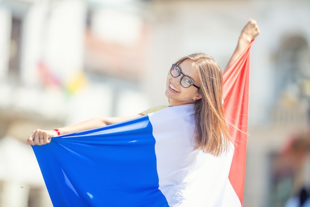 Attraktives glückliches junges Mädchen mit der belgischen Flagge