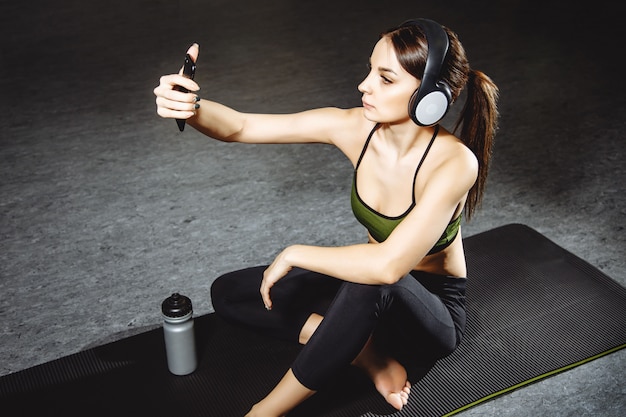 Attraktives Mädchen, das ein selfie nach Übung in der Turnhalle macht