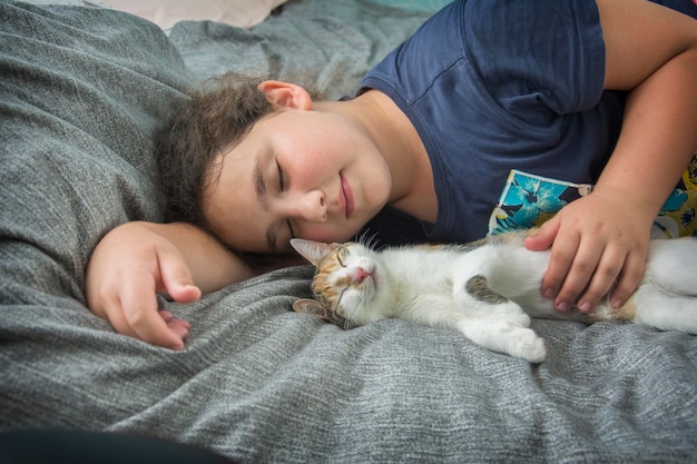 Attraktives Mädchen schläft mit einer Katze auf einem Bett