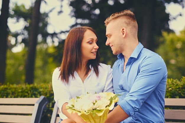 Attraktives Paar bei einem Date. Ein Mann schenkt seiner Freundin einen Blumenstrauß.