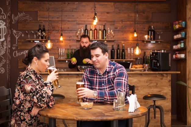 Attraktives Paar, das Bier in einem schönen Hippie-Pub trinkt. Glückliches Paar.