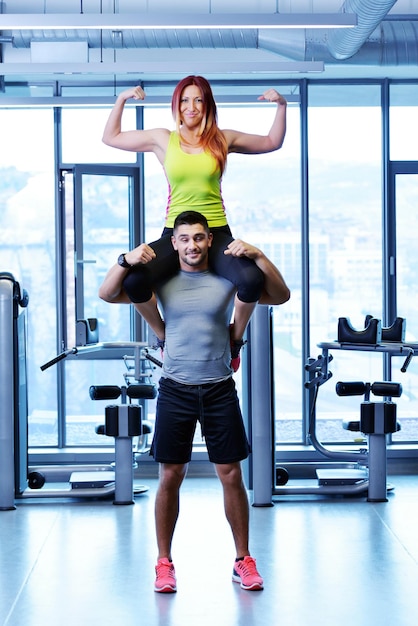 attraktives paar im fitnessstudio sieht glücklich aus