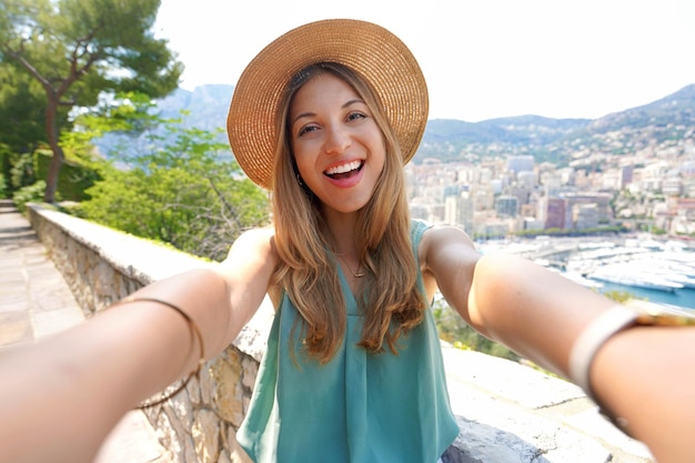 Attraktives Touristenmädchen macht Selfie-Foto mit dem Stadtbild von Monte Carlo Monaco