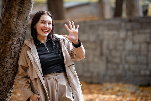 Attraktives und stilvolles Frauenporträt in der Herbstsaison mit Trenchcoat Schild und fünf Tipps cpncept mit Kopierraum