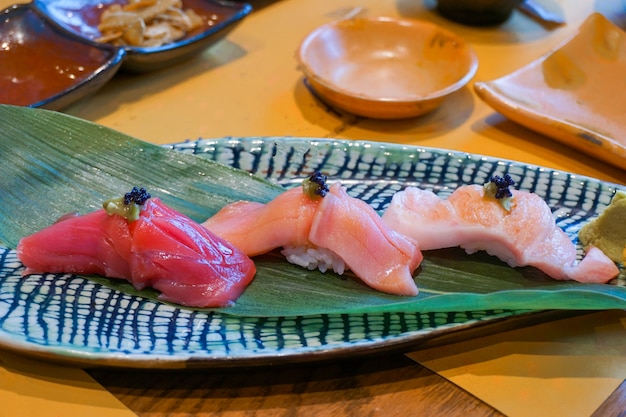 Atum cru fatiado fresco ou soro de sushi otoro, chutoro e akami sushi servido com wasabi em conserva. Comida tradicional japonesa. Foco seletivo.