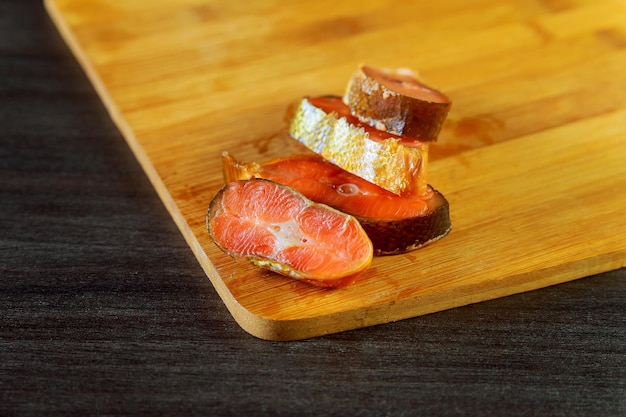 Atum vermelho salmão cru fresco e pedaços de peixe linguado sobre tábua de madeira