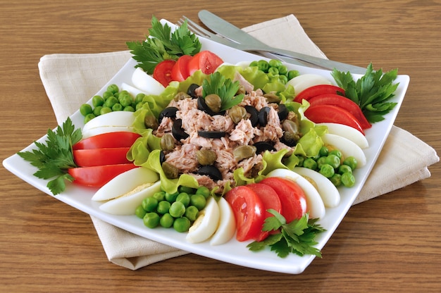 Atún con aceitunas y alcaparras y rodeado de verduras picadas