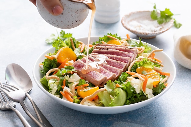 Atún asado con ensalada crocante asiática con naranjas