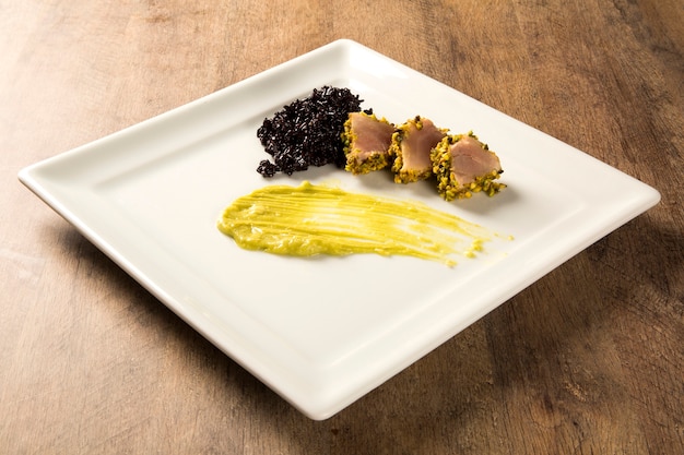 Atún con costra de pistacho, arroz negro y puré de aguacate