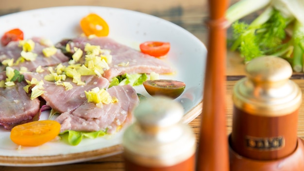 Atún marinado con ensalada y tomates.