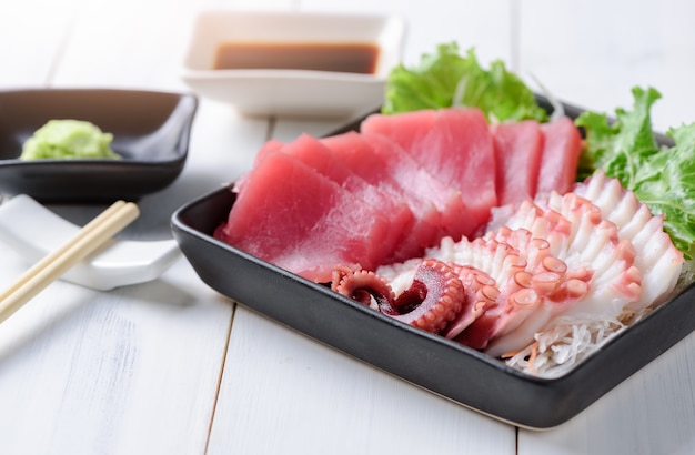 atún sashimi y calamar sobre fondo de madera