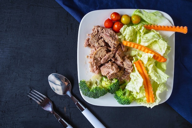 Atún y verduras saludables en un plato sobre la mesa.