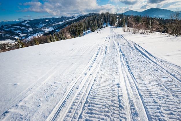Foto atv e pistas de esqui na neve em um dia ensolarado de inverno gelado