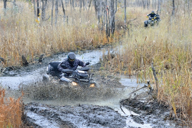 ATV y UTV en acción en pista de agua con salpicaduras de barro de agua. Competencia extrema. 4x4.