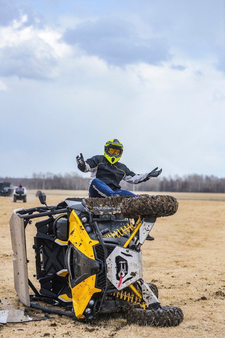 Foto atv utv volcado, el conductor se sienta cerca del vehículo todo terreno averiado