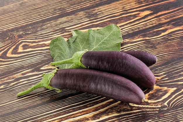 Aubergine púrpura orgânica crua madura com folha