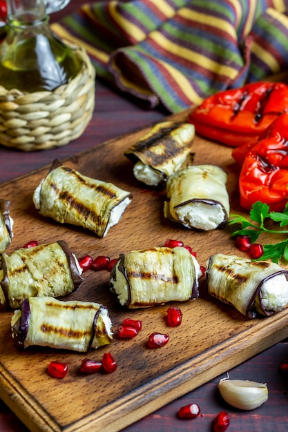 Aubergine rollt mit Käse auf einem hölzernen Hintergrund. Gesundes Essen.