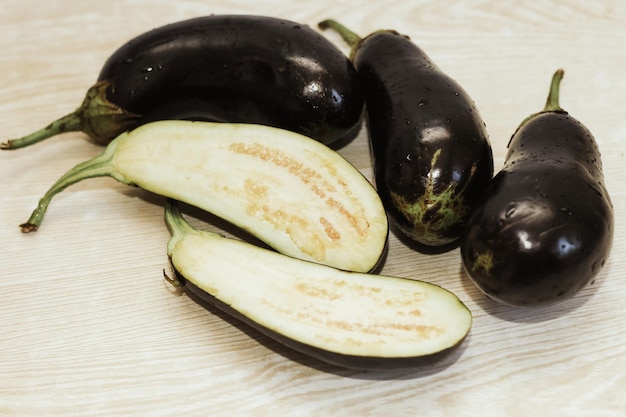 Auberginen werden vor dem Kochen auf einem weißen Tisch geschnitten