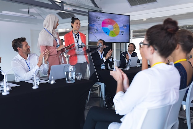 Foto la audiencia aplaude mientras el orador habla en un seminario de negocios