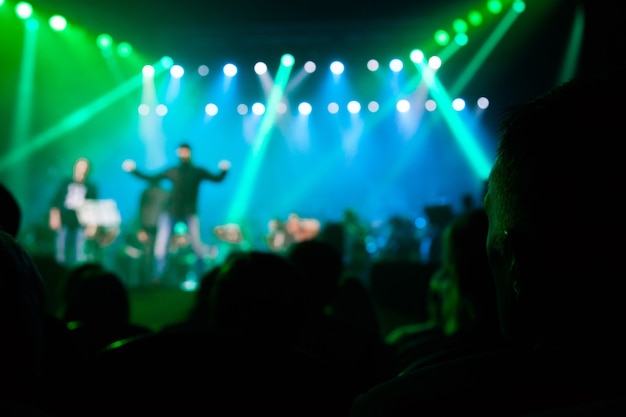 La audiencia en un concierto en el fondo de la escena.