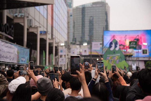 Audiência de concerto turva usando telefones celulares para tirar fotos