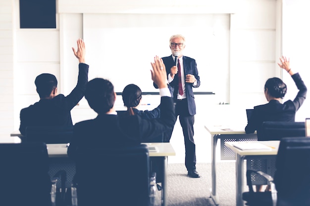 Audiência de negócios levantando a mão e falando em treinamento para parecer em reunião