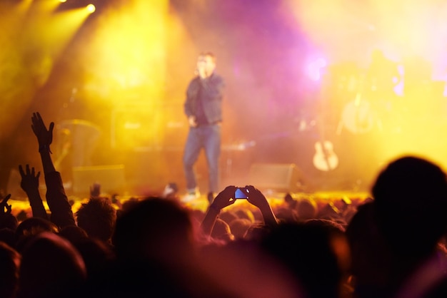 Audiencia del festival de música y manos en la multitud con la banda para el concierto club nocturno y animando con luz fiesta de discoteca y personas con signos gesto y actuación en evento de rock con entretenimiento