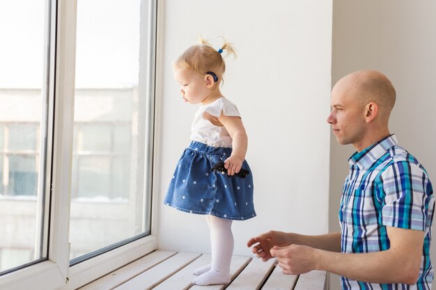 Audífono en el oído de la niña. Niño pequeño que lleva un audífono en casa.