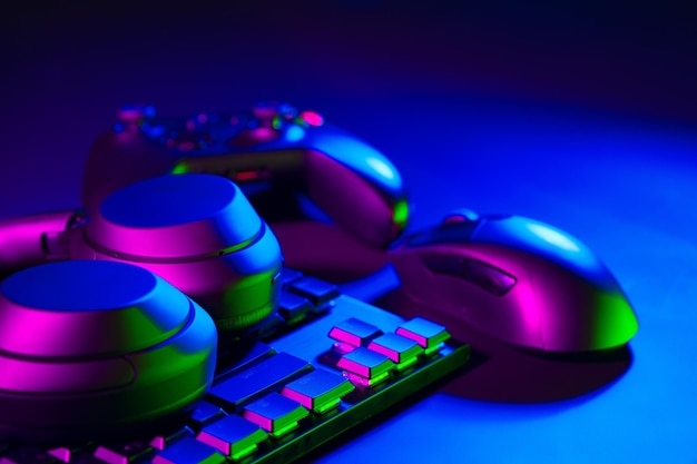 Audífonos, ratón de computadora y teclado sobre fondo negro