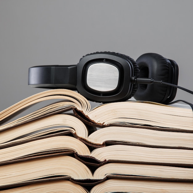 Audiobooks, fones de ouvido na pilha de livros