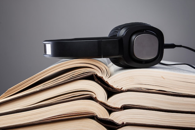 Foto audiobooks, fones de ouvido na pilha de livros