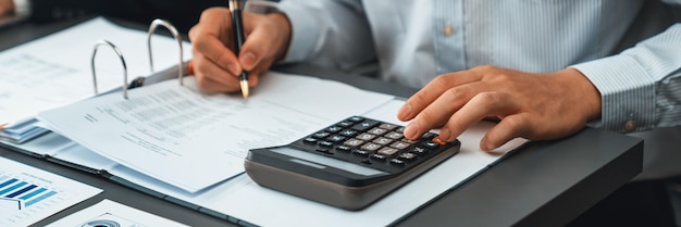 Auditor corporativo calculando orçamento com calculadora em sua mesa de escritório Insight