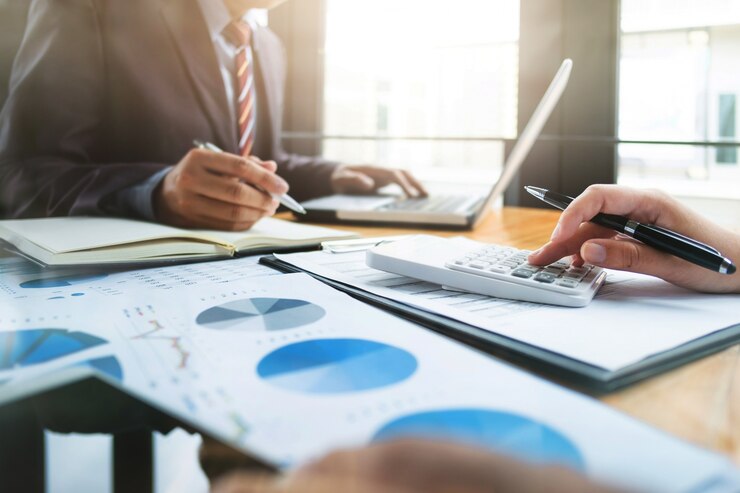 auditorías de negocios utilizando una calculadora de datos financieros de fondo de inversión en un lugar de trabajo, concepto de riqueza